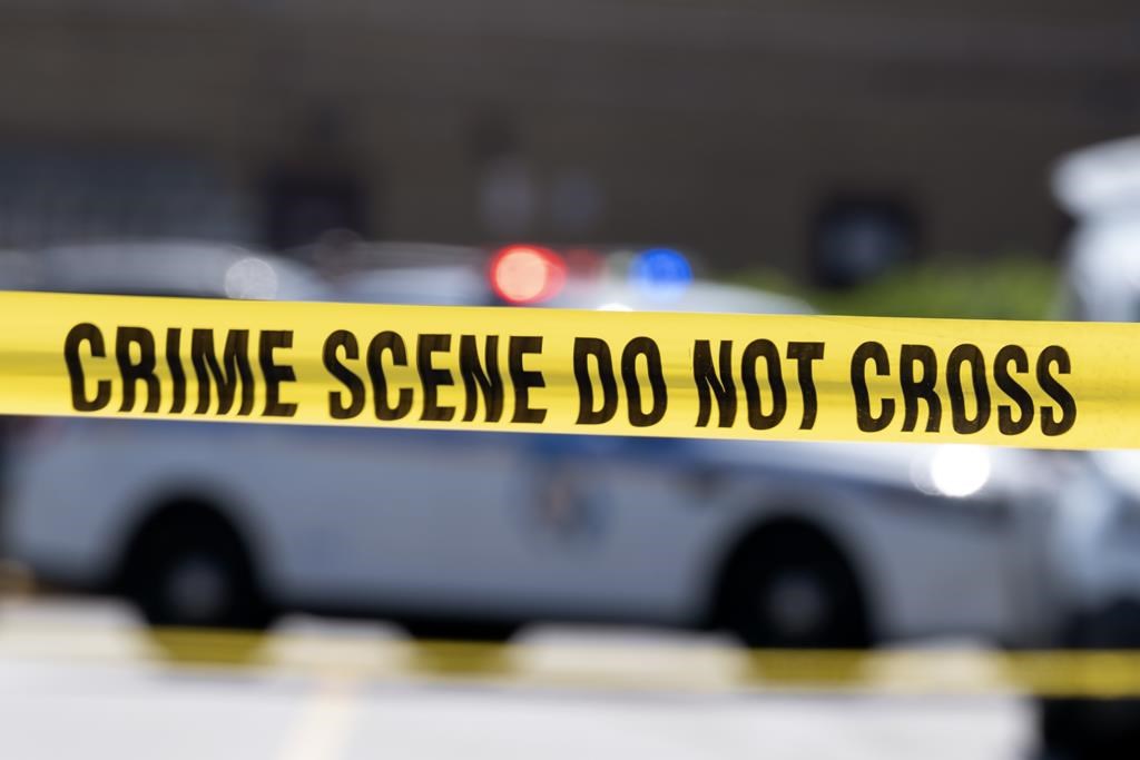 A third person has been charged in the investigation of a 27-year-old woman found dead earlier this month in southwestern Ontario. Police tape blocks off a crime scene July 13, 2021, in Baltimore, Md. 