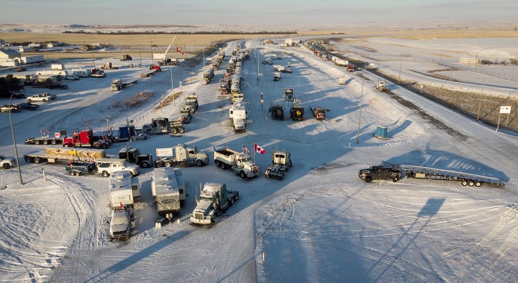 A truck convoy of anti-COVID-19 vaccine mandate demonstrators block the highway at the busy U.S. border crossing in Coutts, Alta., Wednesday, Feb. 2, 2022.