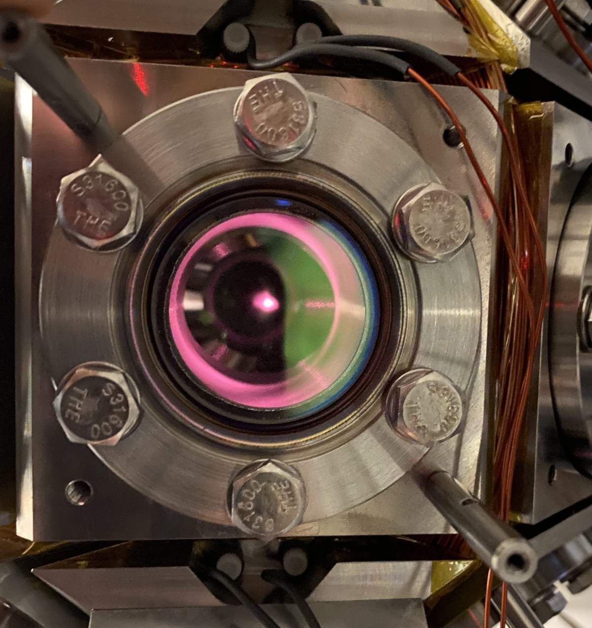 A metal object, with a small window. The rim of the window is lined red, and there is a small red dot in the object's center.