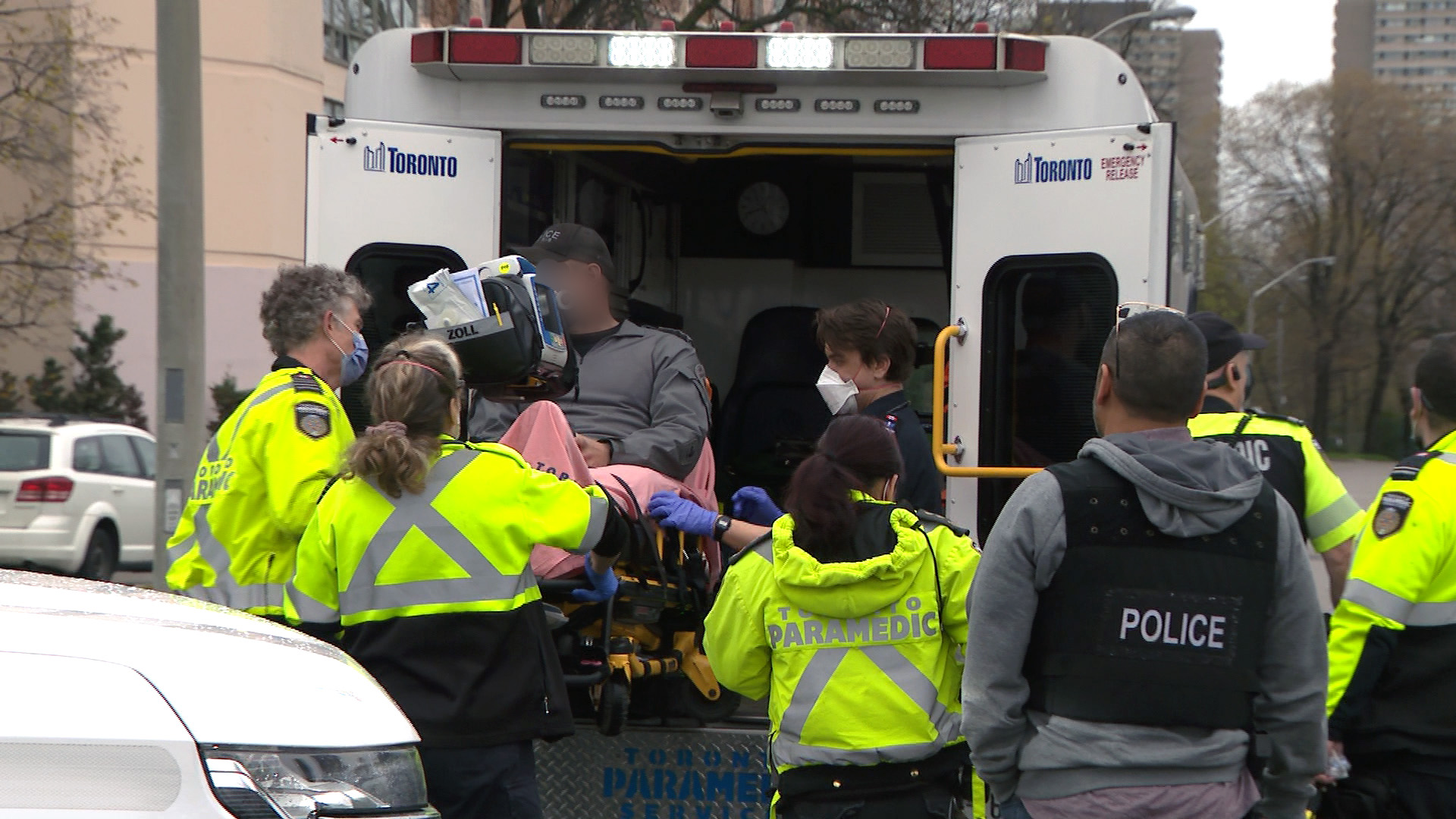 Paramedics load a canine unit officer into an ambulance after he was struck by a fleeing vehicle.