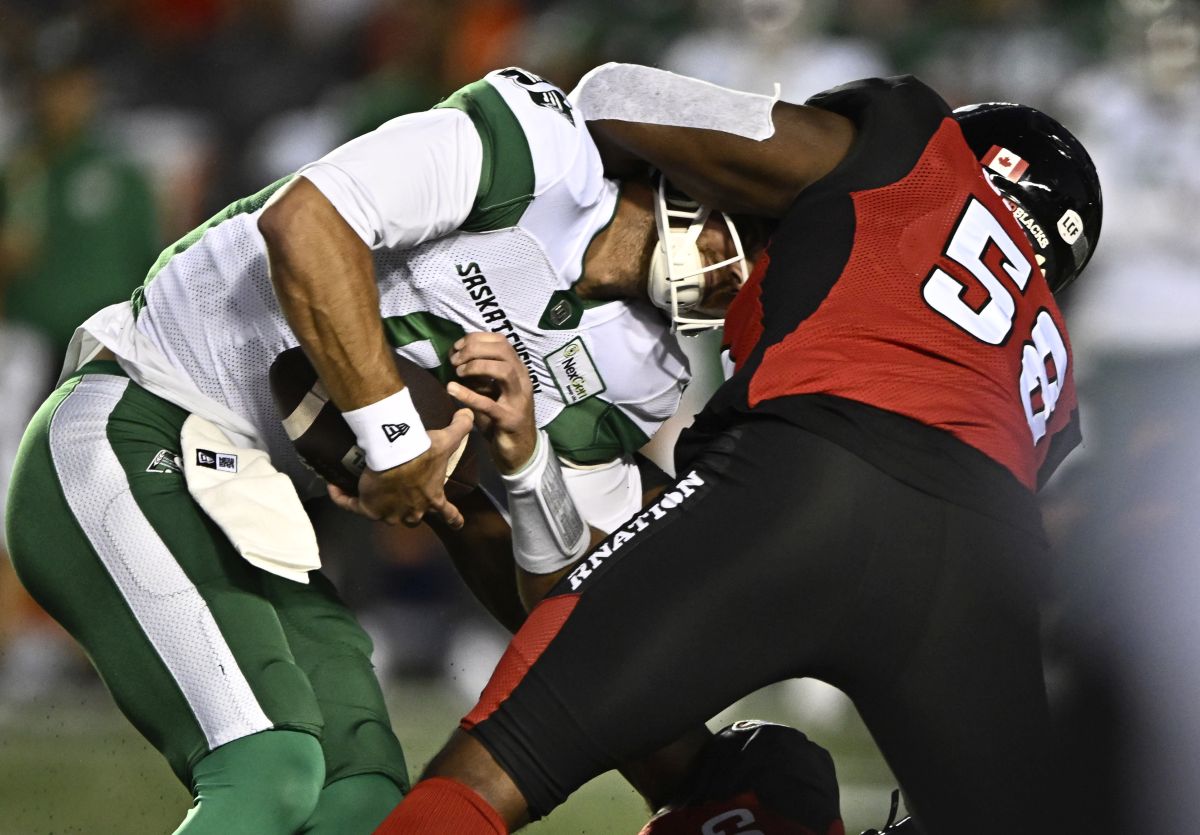 Saskatchewan Roughriders quarterback Jake Dolegala (9) is sacked by Ottawa Redblacks defensive lineman Bryce Carter (58) during first half CFL football action in Ottawa on Friday, Sept. 22, 2023.