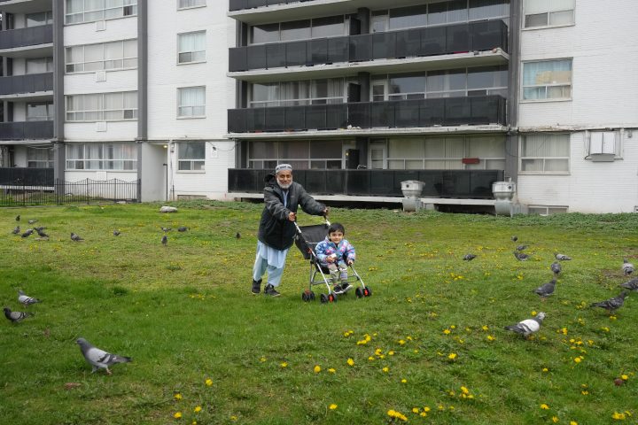 A resident pushes his grandson in a stroller outside of 75 Thorncliffe Park Drive in Toronto, as seen on Sunday, April 28, 2024. 