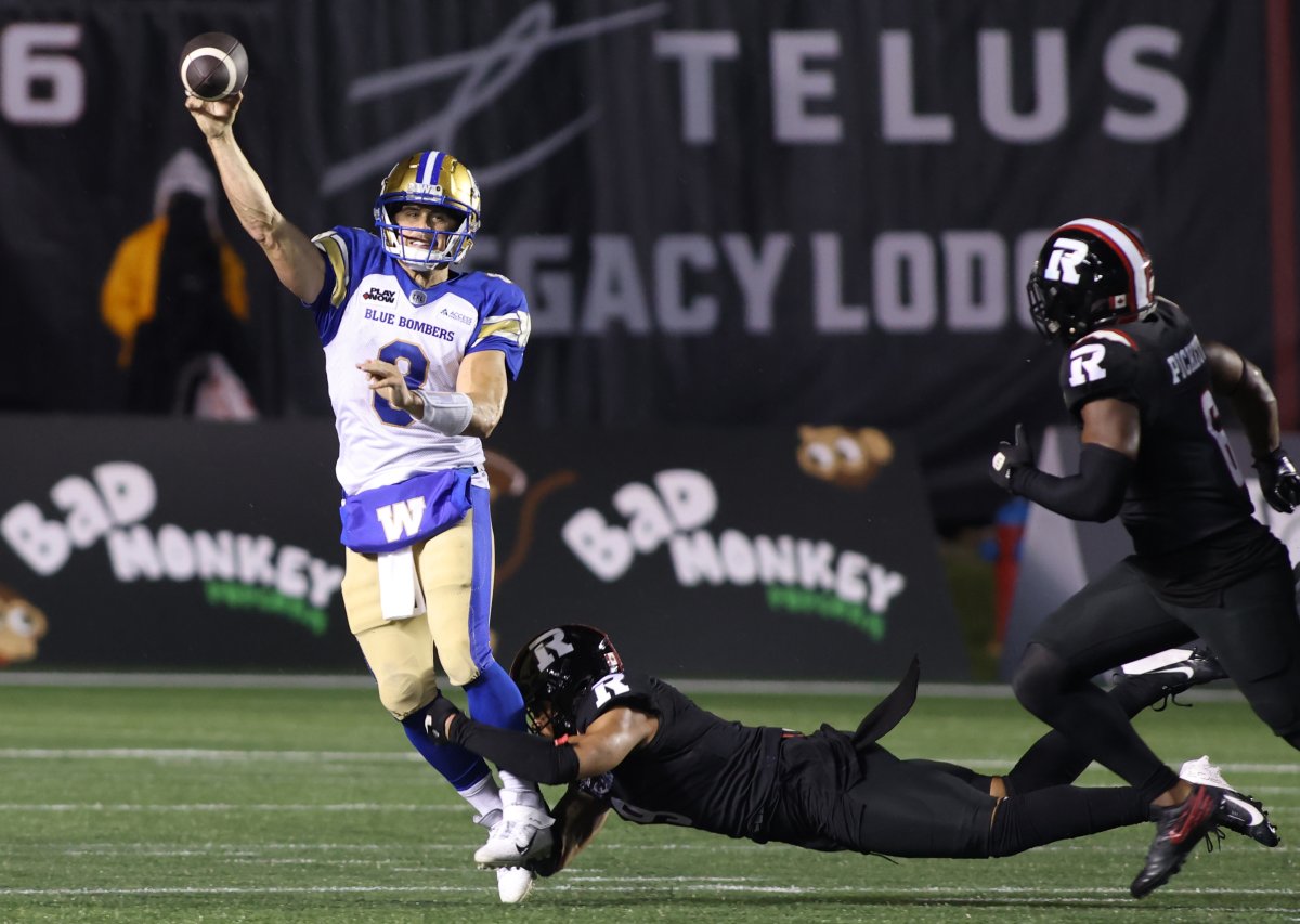 Winnipeg Blue Bombers quarterback Zach Collaros (8) throws the ball while Ottawa Redblacks' Damon Webb (9) tries to tackle him during second half CFL action in Ottawa on Thursday, June 13, 2024.  THE CANADIAN PRESS/ Patrick Doyle.