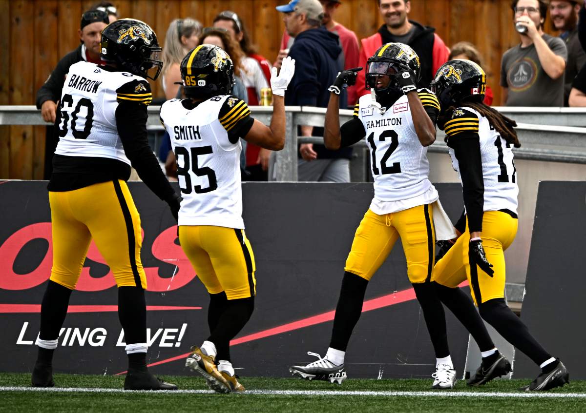 Hamilton Tiger-Cats' Tim White (12) celebrates a touchdown against the Ottawa Redblacks with teammates during the game in Ottawa on Sunday.