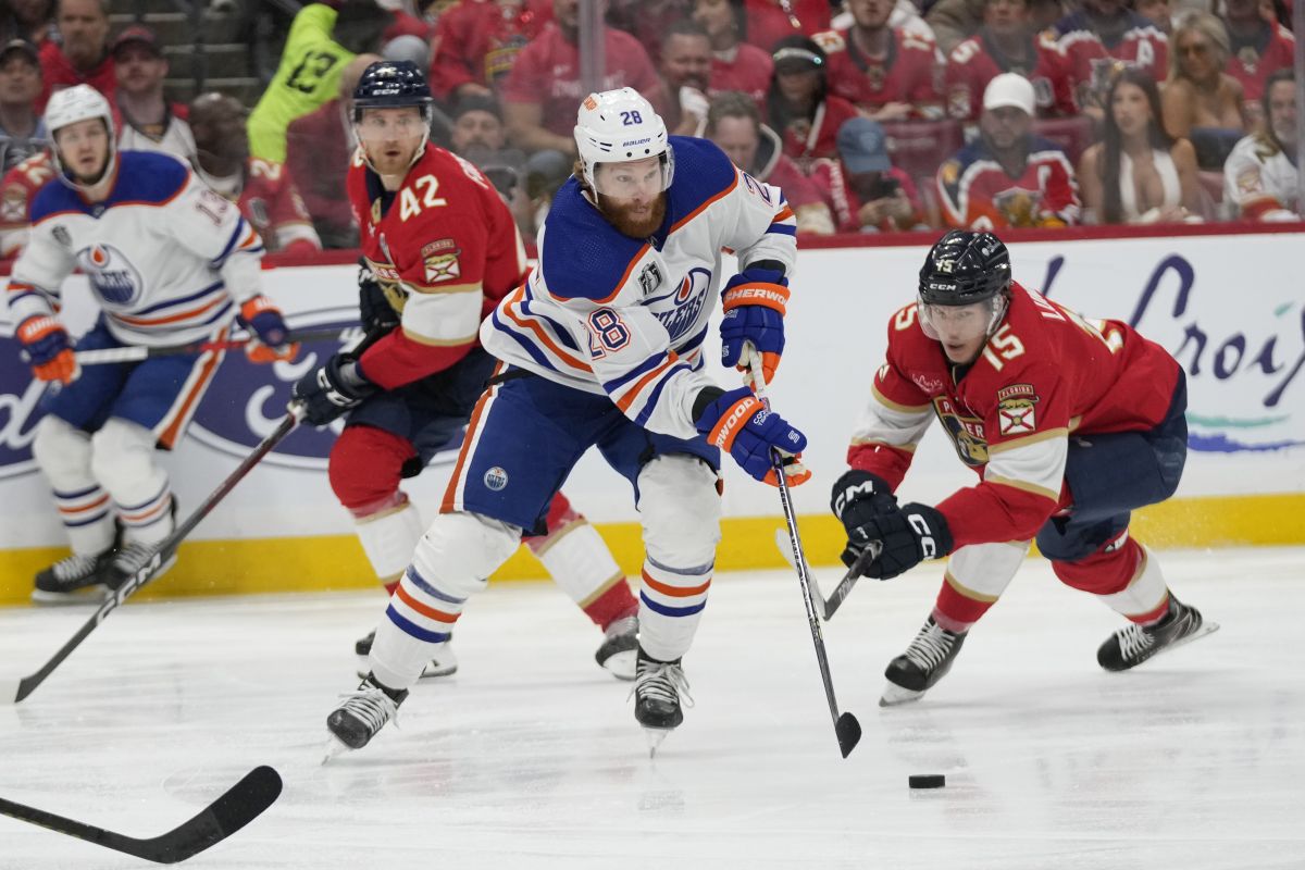 Edmonton Oilers right wing Connor Brown (28) controls the puck as Florida Panthers centre Anton Lundell (15) defends during the first period of Game 5 of the NHL hockey Stanley Cup Finals, Tuesday, June 18, 2024, in Sunrise, Fla.