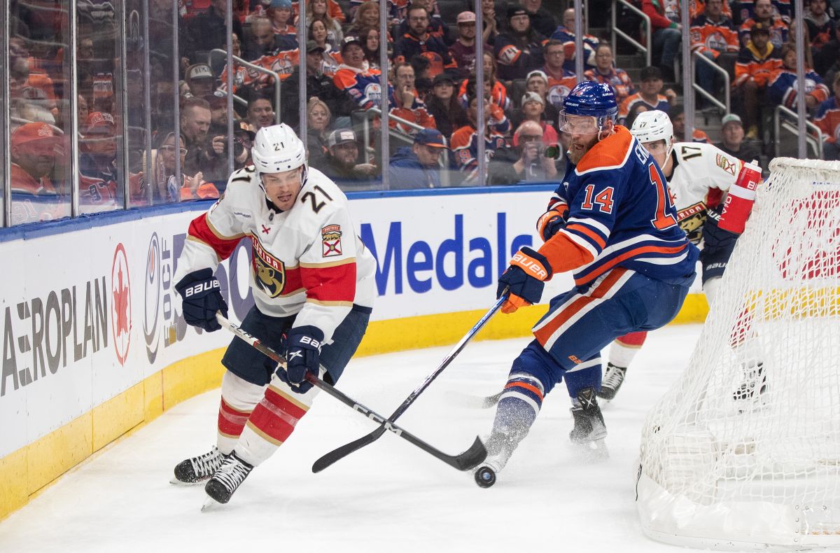Florida Panthers' Nick Cousins (21) and Edmonton Oilers' Mattias Ekholm (14) battle for the puck during first period NHL action in Edmonton on Saturday December 16, 2023.