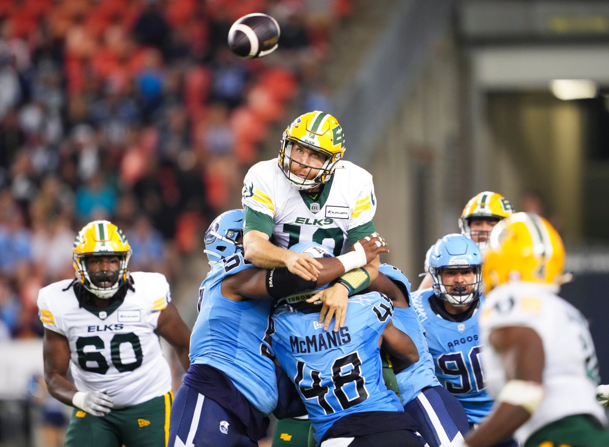 Edmonton Elks quarterback McLeod Bethel-Thompson (10) throws a pass under pressure from linebacker Wynton McManis (48) and defensive lineman Ralph Holley (99) during second half CFL football action in Toronto, Saturday, June 22, 2024.