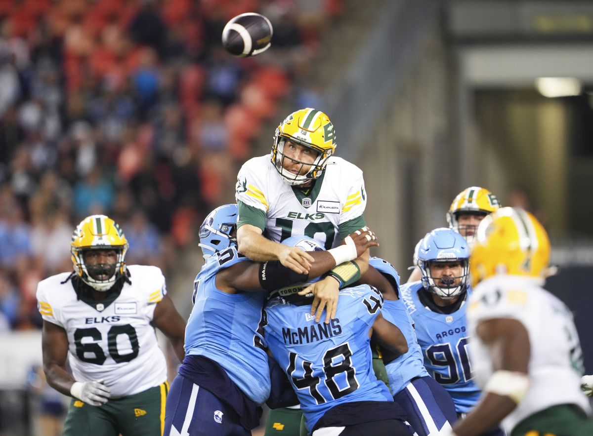 Edmonton Elks quarterback McLeod Bethel-Thompson (10) throws a pass under pressure from linebacker Wynton McManis (48) and defensive lineman Ralph Holley (99) during second half CFL football action in Toronto, Saturday, June 22, 2024.