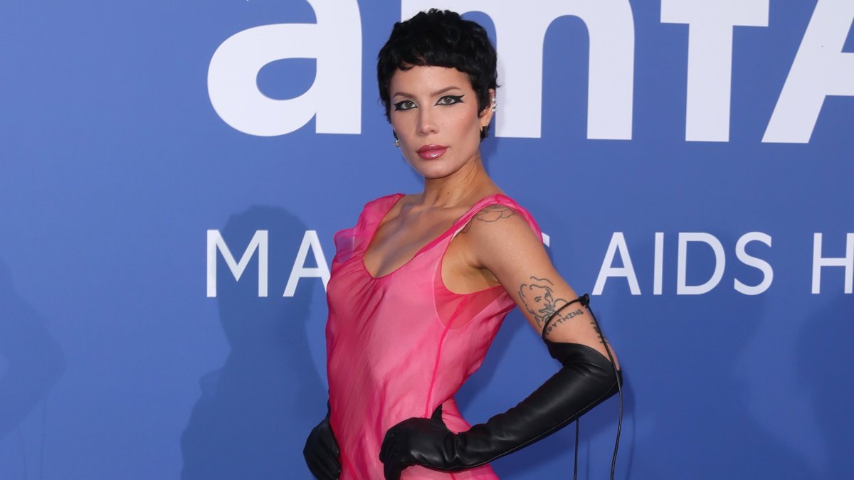 Halsey in a pink dress with long black gloves. Her hair is dark and short.