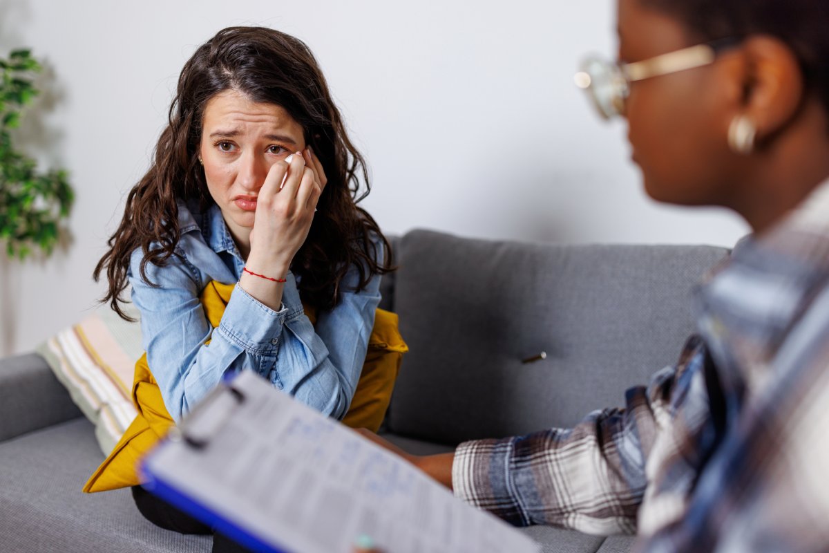 A sad lady talking to someone after finding out she has been denied long-term disability for Parkinson's disease