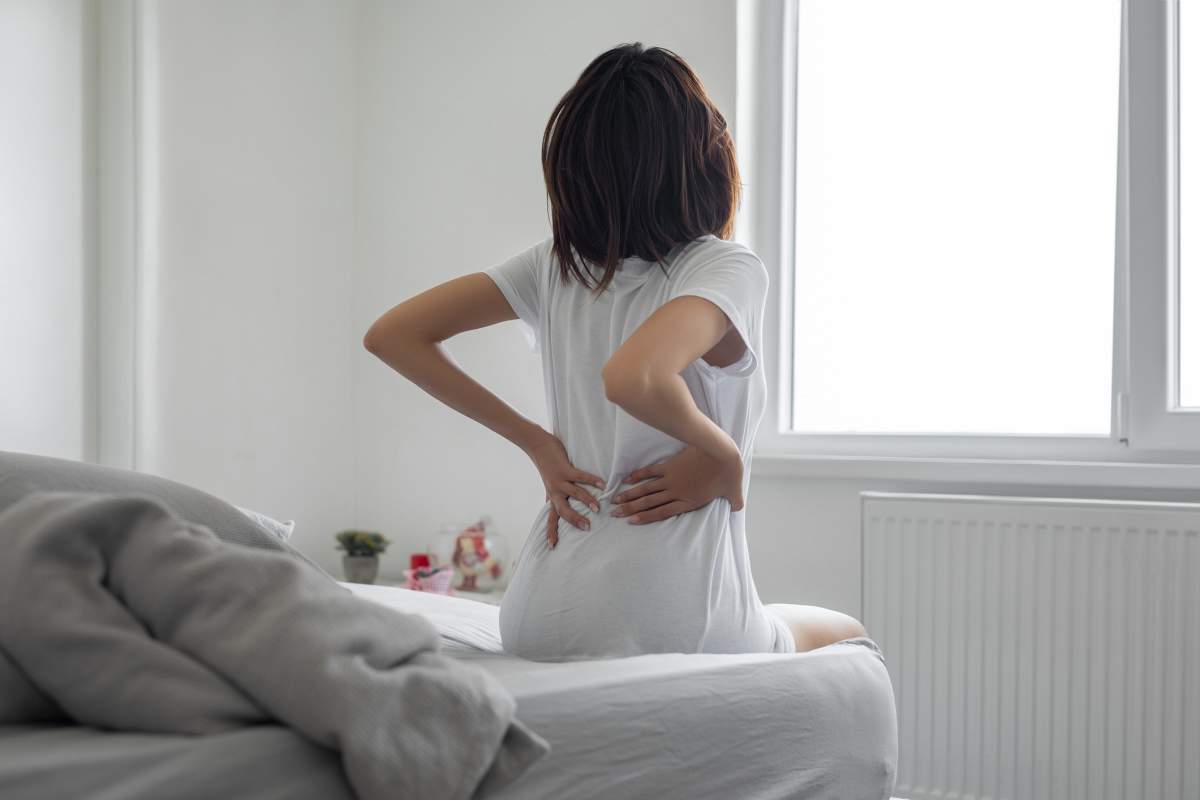Woman feels back pain massaging aching muscles