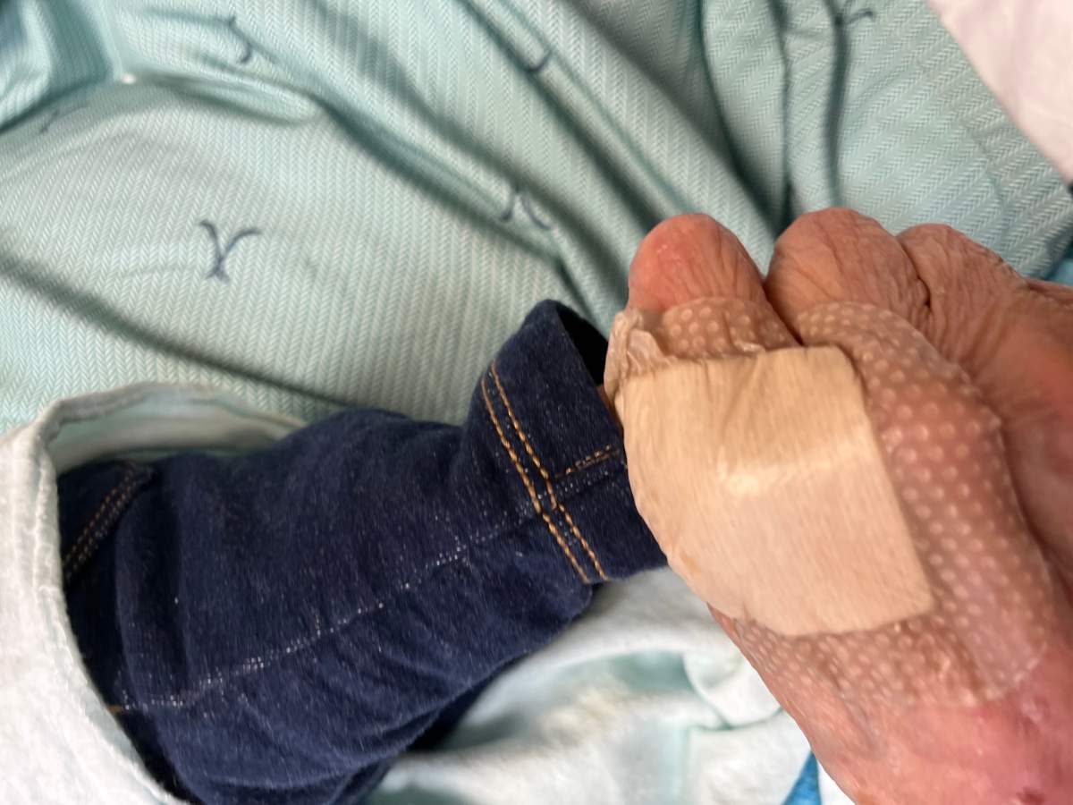 Catherine Day holding her three-day-old great-grandson’s foot while she was in hospital. She died days later.