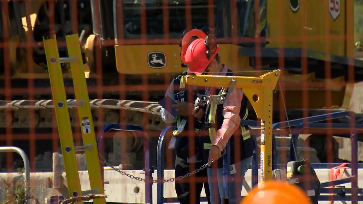 Occupational Health and Safety personnel seen at the site of a broken feeder main in Calgary on June 13, 2024. The night before, two workers were injured while working at the site.