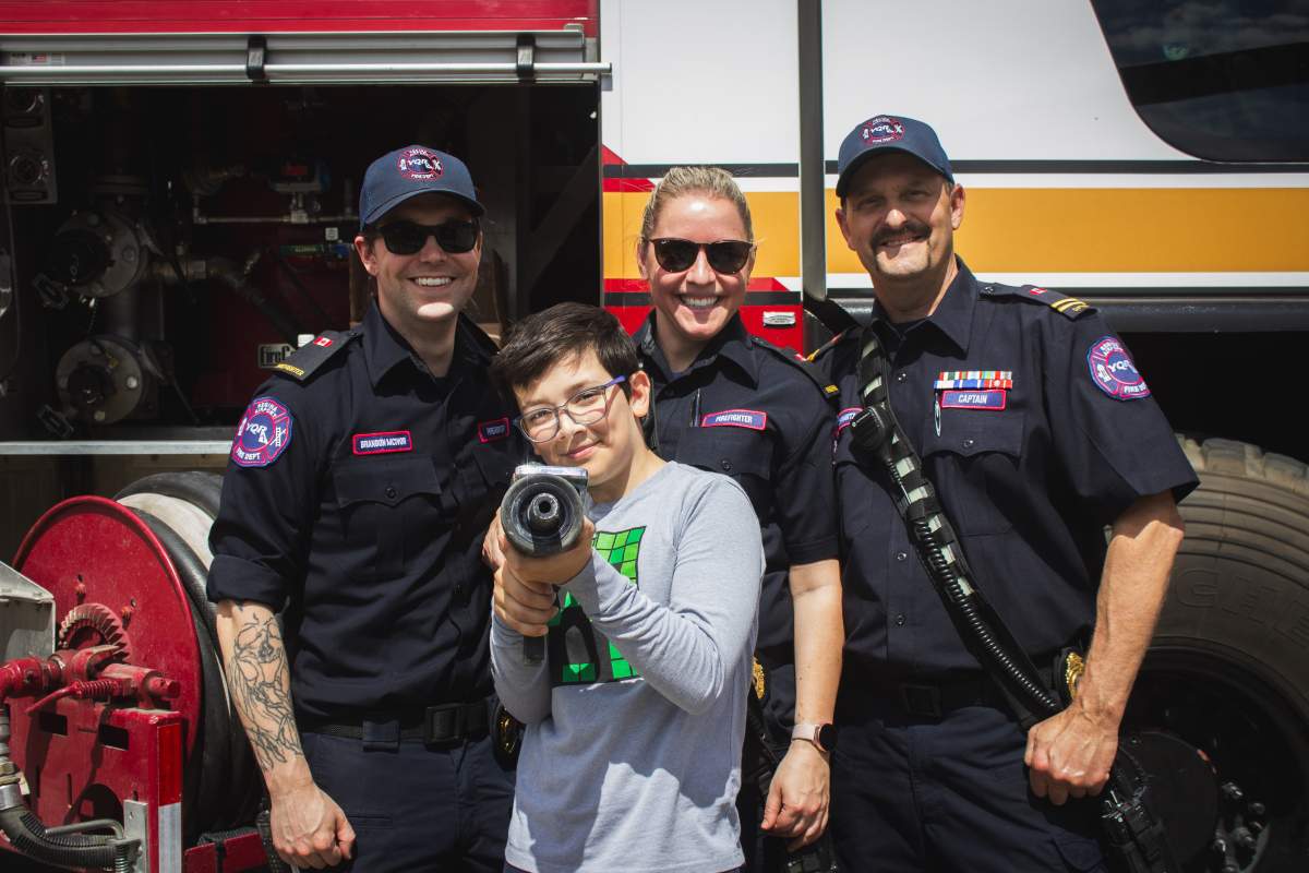 Members of the Regina International Airport fire department pose with one young aviation fan.