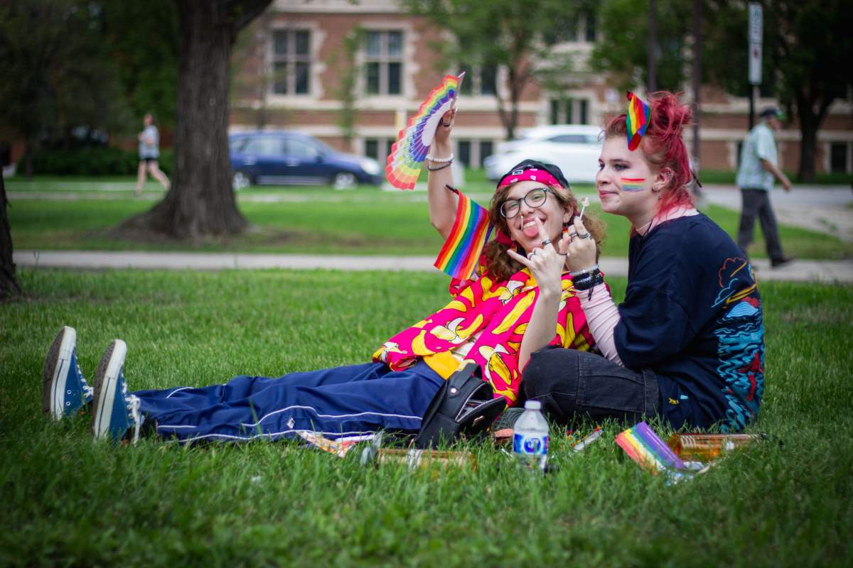 Two Regina residents look on as the pride parade heads through Regina.