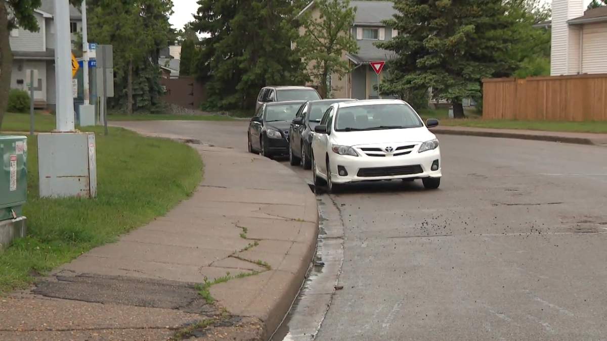 Vehicles parked on the street outside a condo complex in northwest Edmonton's Dunluce neighbourhood on Wednesday, June 12, 2024.