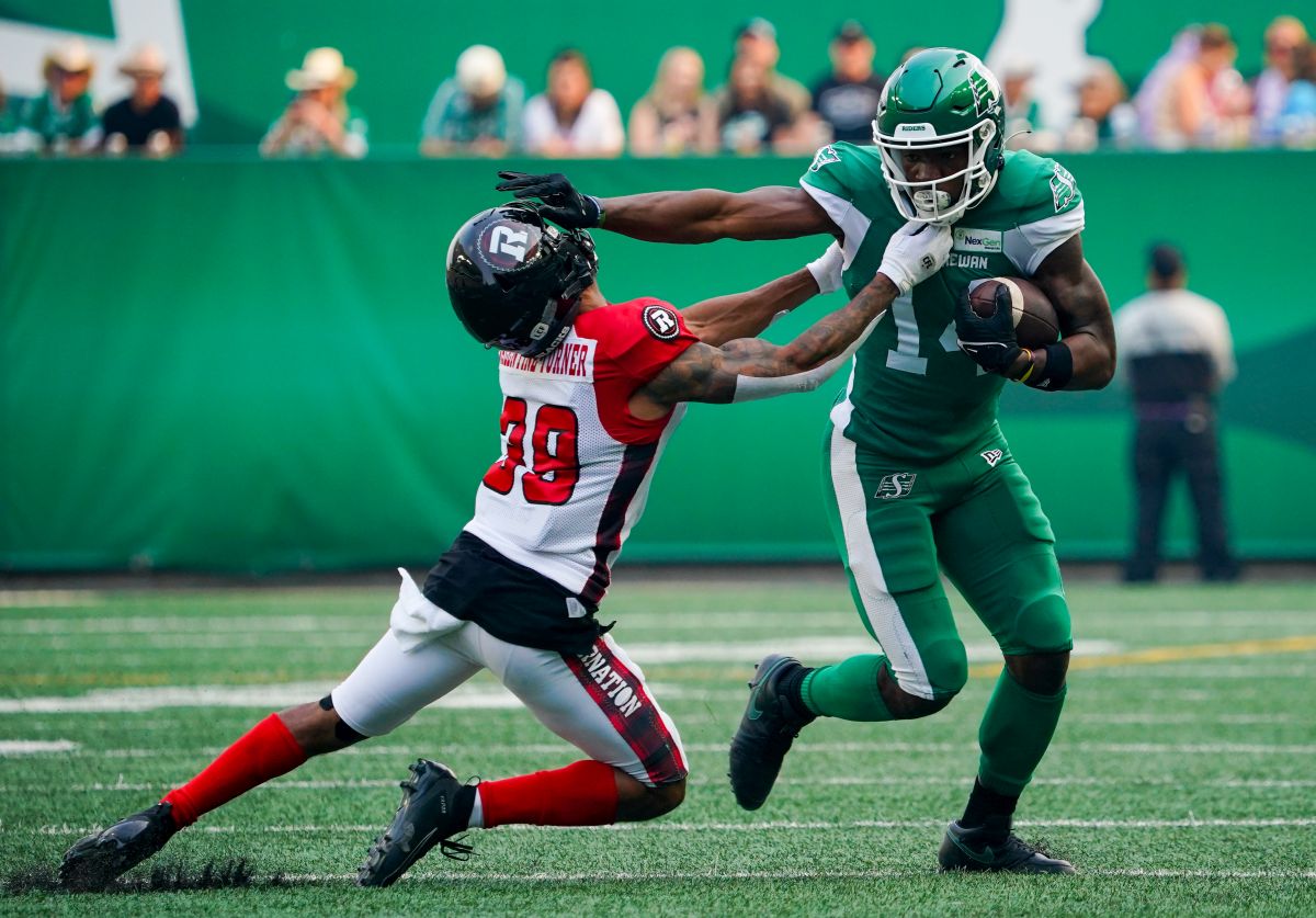 Saskatchewan Roughriders receiver Tevin Jones (14) stiff arms Ottawa Redblacks defensive back Josh Valentine-Turner (39) during the first half of CFL football action in Regina on Sunday, August 6, 2023.