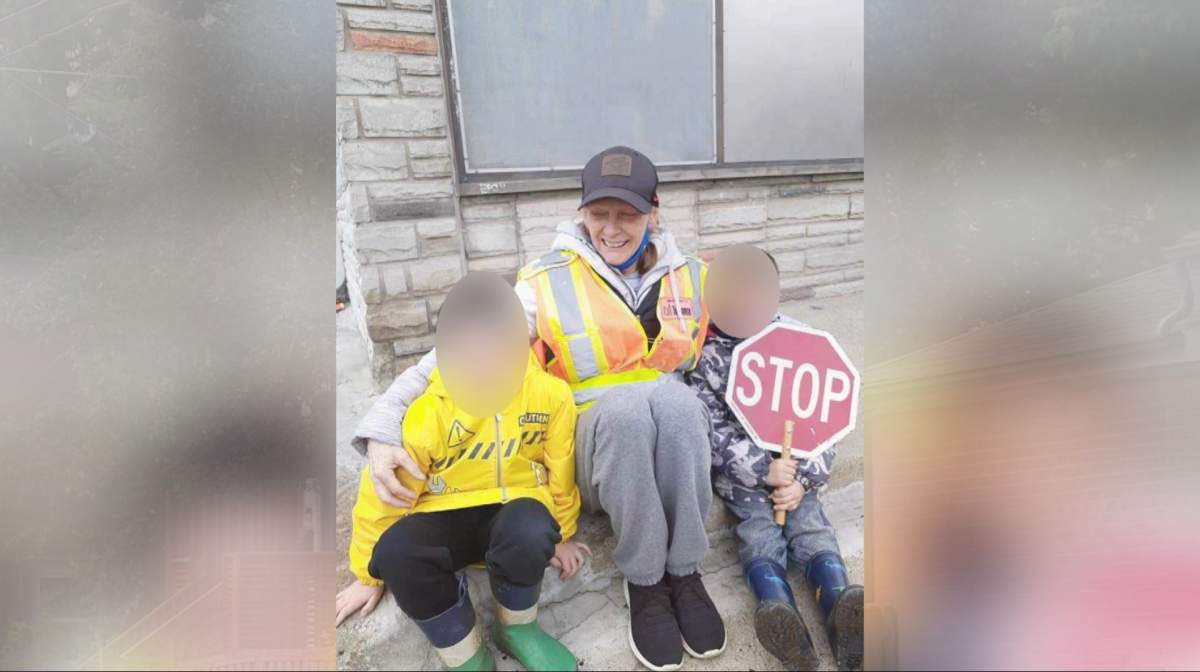 crossing guard holding two kids