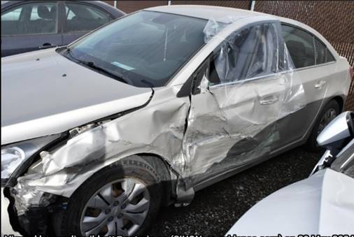 A grey car with damage on its side.