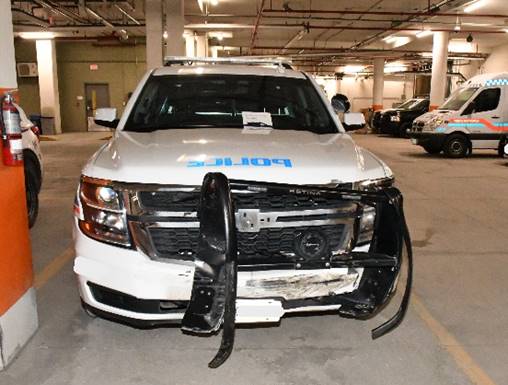 A photo of a damaged police vehicle in a garage.