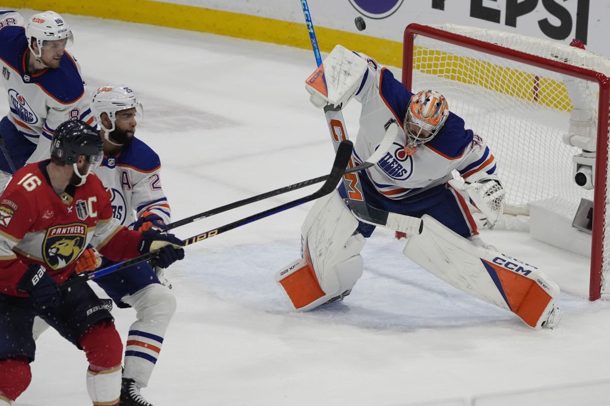 Edmonton Oilers goaltender Stuart Skinner (74) deflects a shot on goal during the third period of Game 5 of the NHL hockey Stanley Cup Finals against the Florida Panthers, Tuesday, June 18, 2024, in Sunrise, Fla.