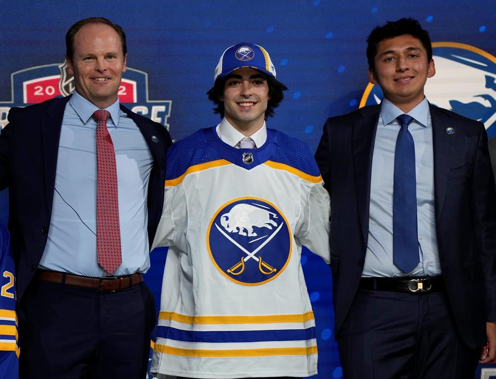 Matt Savoie poses with team officials after being selected 9th by the Buffalo Sabres during the first round of the 2022 NHL Draft in Montreal on July 7, 2022.
