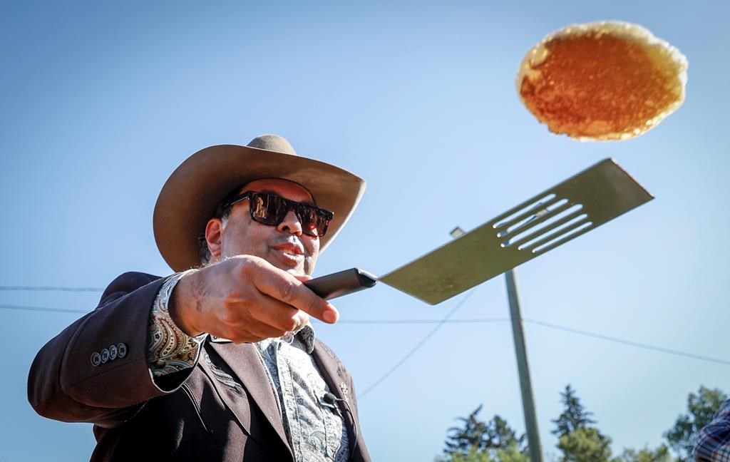 Alberta NDP leader Naheed Nenshi flips pancakes during a pancake breakfast in Calgary, Alta., Sunday, July 7, 2024.