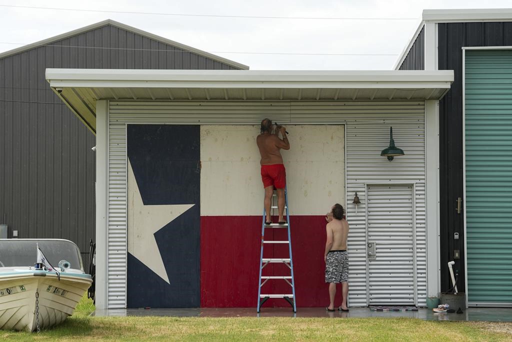 Clyde George, left, and his son Chris George board up their home ahead of the arrival of Tropical Storm Beryl on Sunday, July 7, 2024, in Port O’Connor, Texas.
