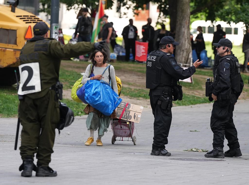 A woman leaves the pro-Palestinian encampment at McGill University with her belongings in Montreal, Wednesday, July 10, 2024. Police have cordoned off the streets surrounding the university as McGill security begins to dismantle the encampment.