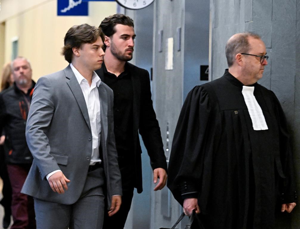 Two former Victoriaville Tigres hockey players follow a defence lawyer out of the courtroom after pleading guilty.