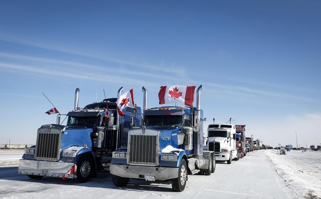 A truck convoy of anti-COVID-19 vaccine mandate demonstrators block the highway at the busy U.S. border crossing in Coutts, Alta., Wednesday, Feb. 2, 2022.