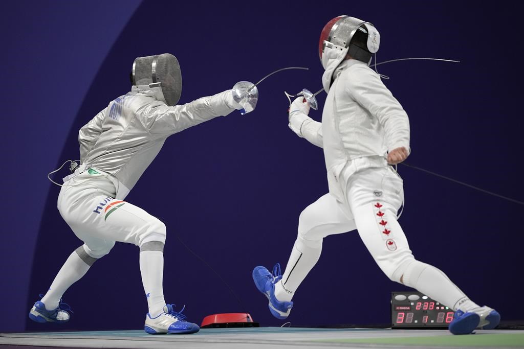 Hungary's Aron Szilagyi, left, and Canada's Fares Arfa compete in the men's individual Sabre round of 32 competition during the 2024 Summer Olympics at the Grand Palais, Saturday, July 27, 2024, in Paris, France. THE CANADIAN PRESS/AP/Andrew Medichini.