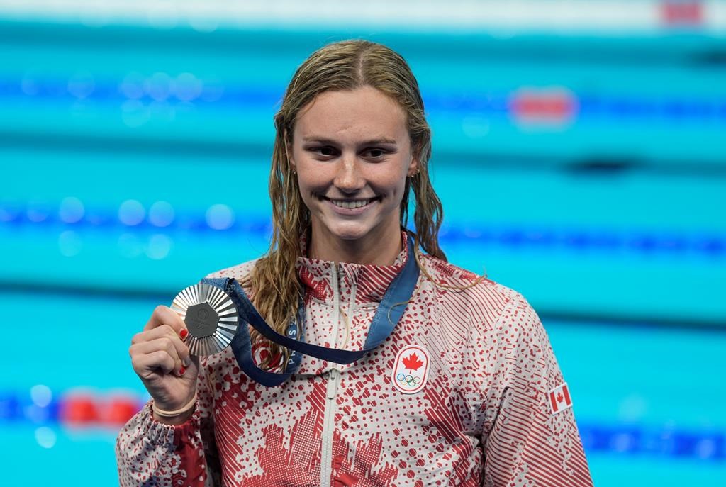 Summer McIntosh, of Canada, smiles as she holds her silver medal after the women's 400-meter freestyle final at the 2024 Summer Olympics, Saturday, July 27, 2024, in Nanterre, France. THE CANADIAN PRESS/Adrian Wyld.