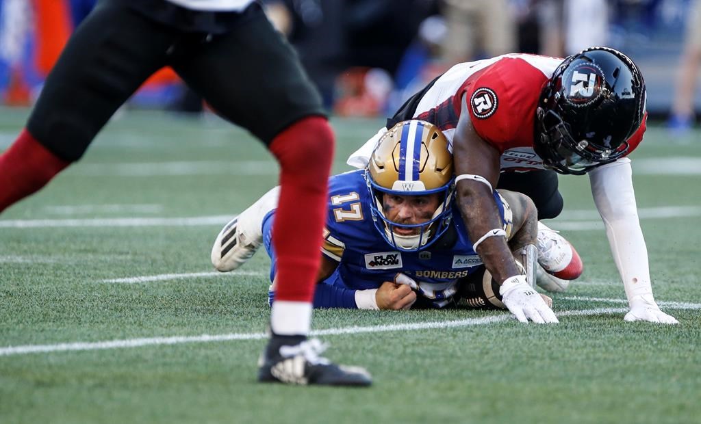 Winnipeg Blue Bombers quarterback Chris Streveler (17) gets tackled by Ottawa Redblacks' Adarius Pickett (6) during first half CFL action in Winnipeg Friday, July 5, 2024.  Ottawa (5-2) has won three straight contests and remains unbeaten at home. THE CANADIAN PRESS/John Woods.