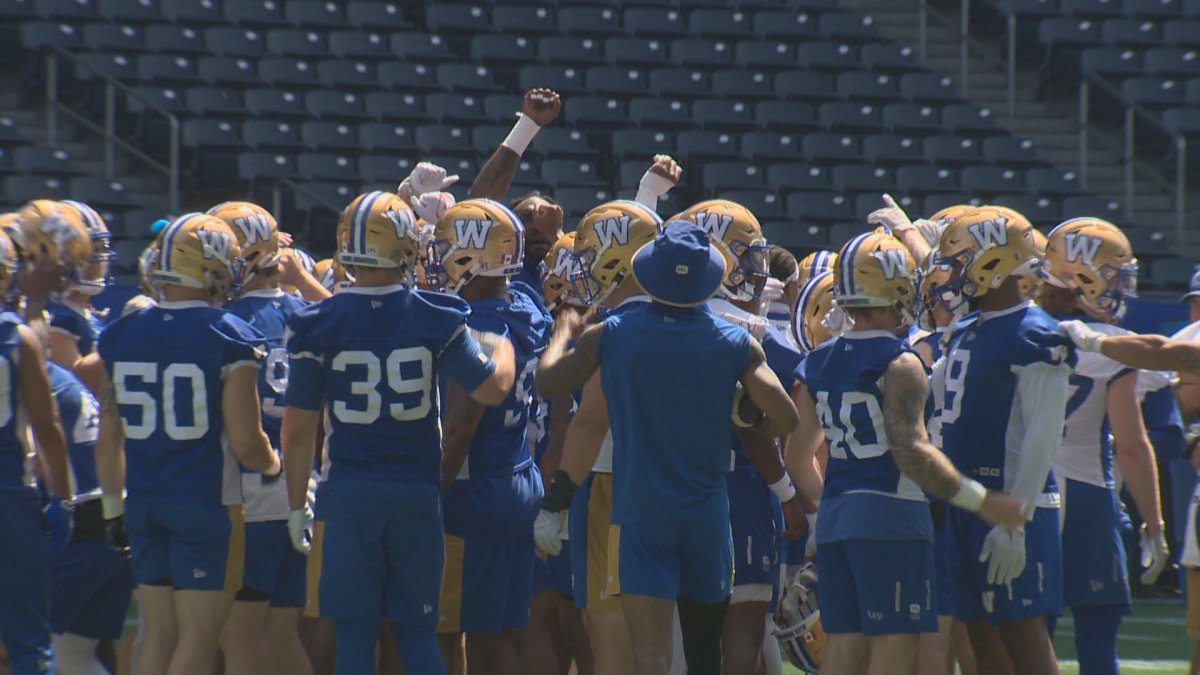 Winnipeg Blue Bombers players gather on the field ahead of practice.