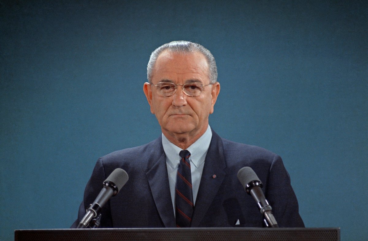 Former U.S. President Lyndon B. Johnson in front of two microphones.