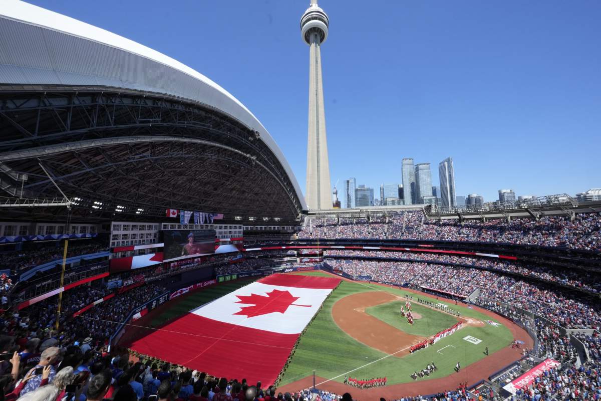 A huge Canadian flag is unfurled before the start of the American League baseball game between the Houston Astros and the Toronto Blue Jays in Toronto on Canada Day, Monday, July 1, 2024. THE CANADIAN PRESS/Frank Gunn