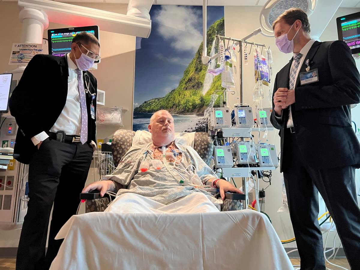 In this photo provided by the Mayo Clinic, Dr. Girish Mour, left, medical director of Mayo Clinic's Larynx and Trachea Transplant Program, and Dr. David Lott, right, standing on either side of Marty Kedian one week after his transplant surgery in Phoenix, March 8, 2024. Kedian regained his voice after surgeons removed his cancerous larynx and, in a pioneering move, immediately replaced it with a donated one. (Mayo Clinic via AP)