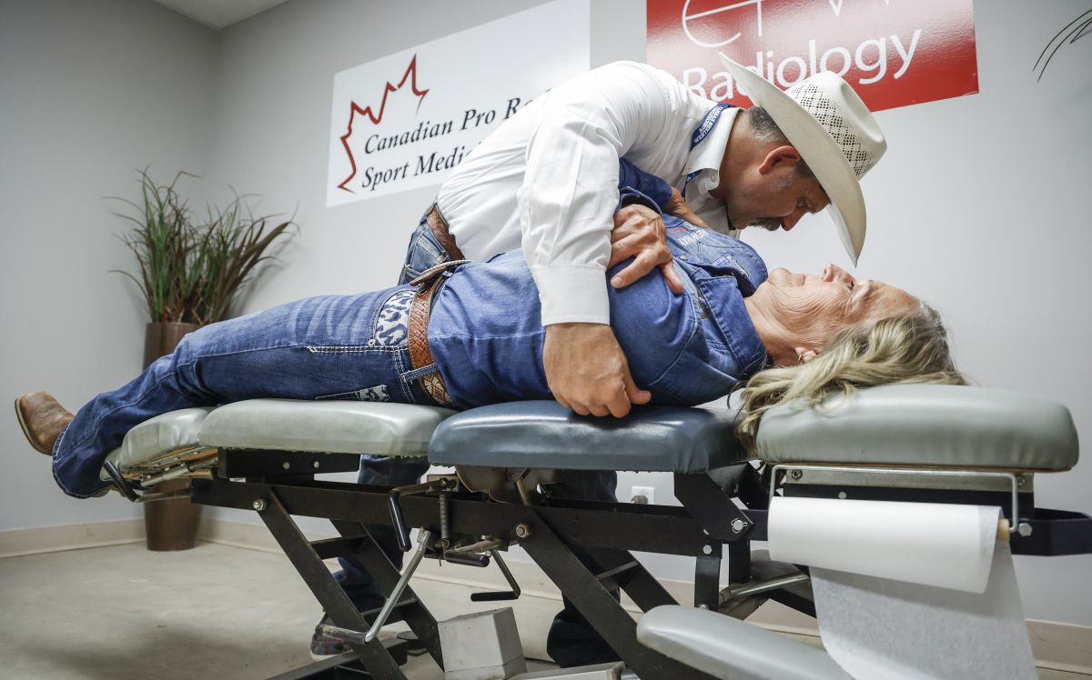 Dr. Blaine Bugg, left, treats barrel racer Lynette Brodoway at the Calgary Stampede's rodeo medical clinic in Calgary, Alta., Thursday, July 4, 2024.