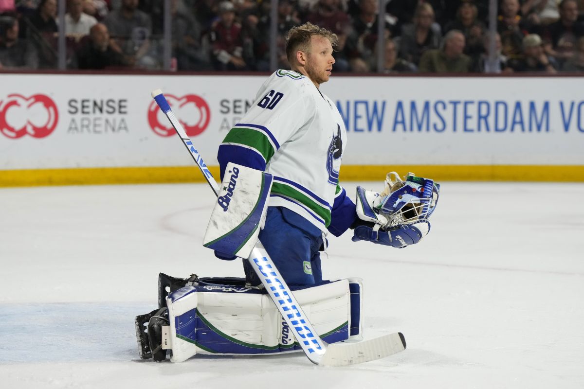 Vancouver Canucks goaltender Collin Delia holds his helmet during the third period of the team's NHL hockey game against the Arizona Coyotes, Thursday, April 13, 2023, in Tempe, Ariz. The Canucks won 5-4 in overtime.