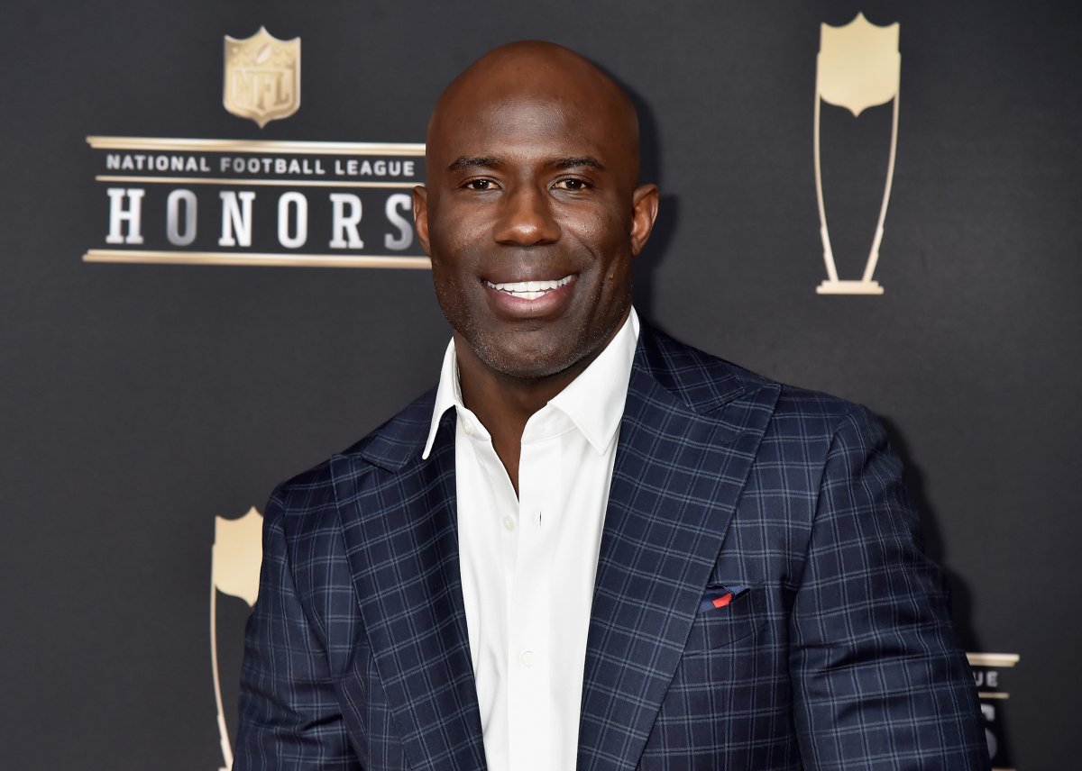 Terrell Davis in a blue suit and white button up. He is smiling.