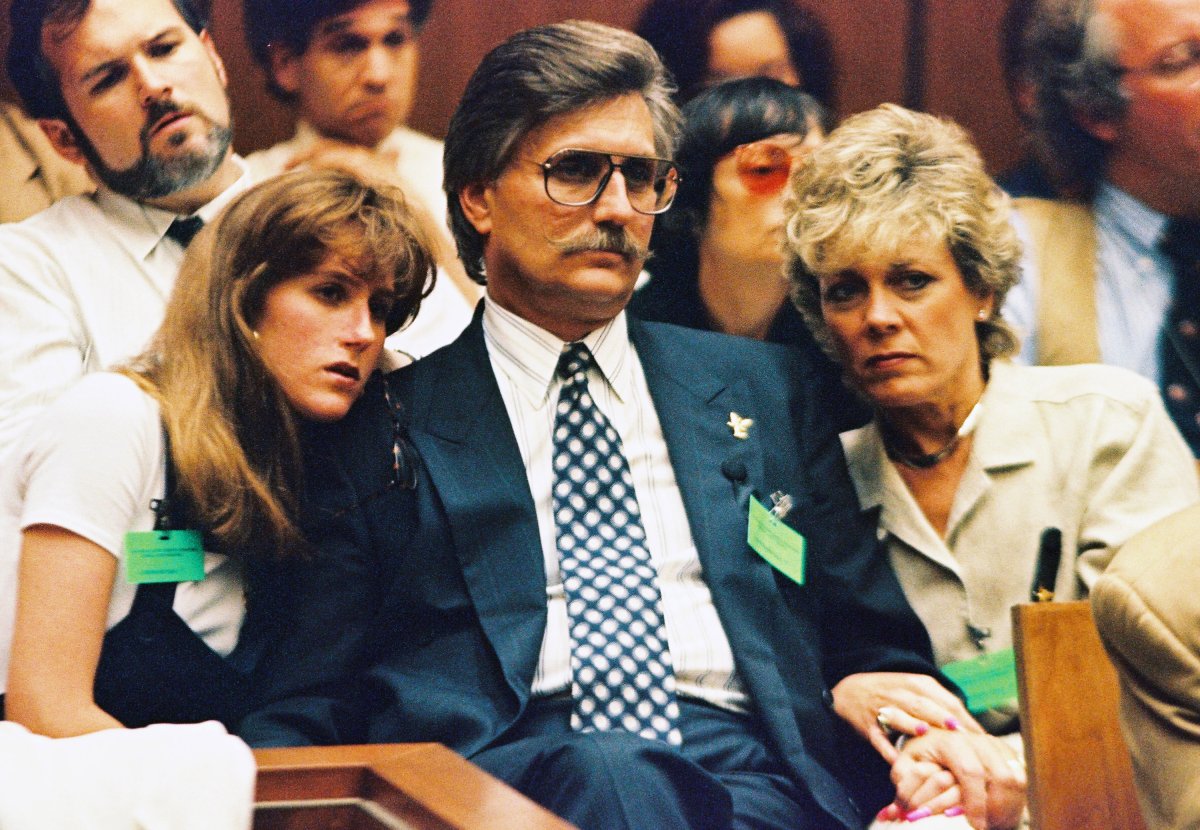 Fred Goldman sits with two women on each side of him.