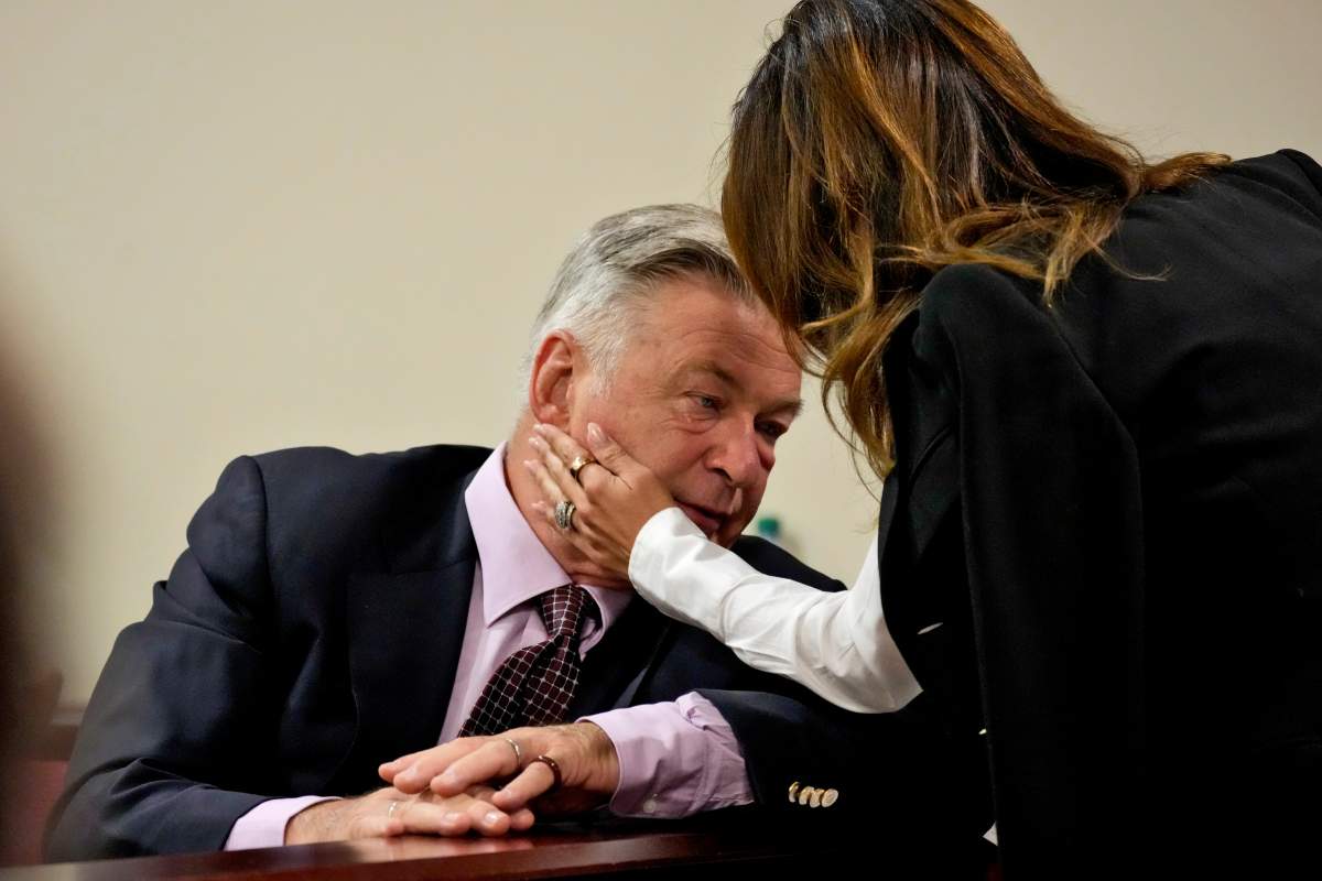Hilaria Baldwin caresses the cheek of Alec Baldwin in court. They are holding hands.