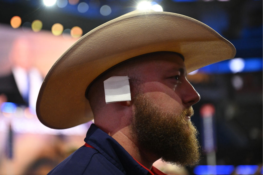 Texas delegate Jackson Carpenter wears a bandage on his ear, like the one worn by US former President and 2024 Republican presidential candidate Donald Trump following his assassination attempt, during the third day of the 2024 Republican National Convention at the Fiserv Forum in Milwaukee, Wisconsin, on July 17, 2024.