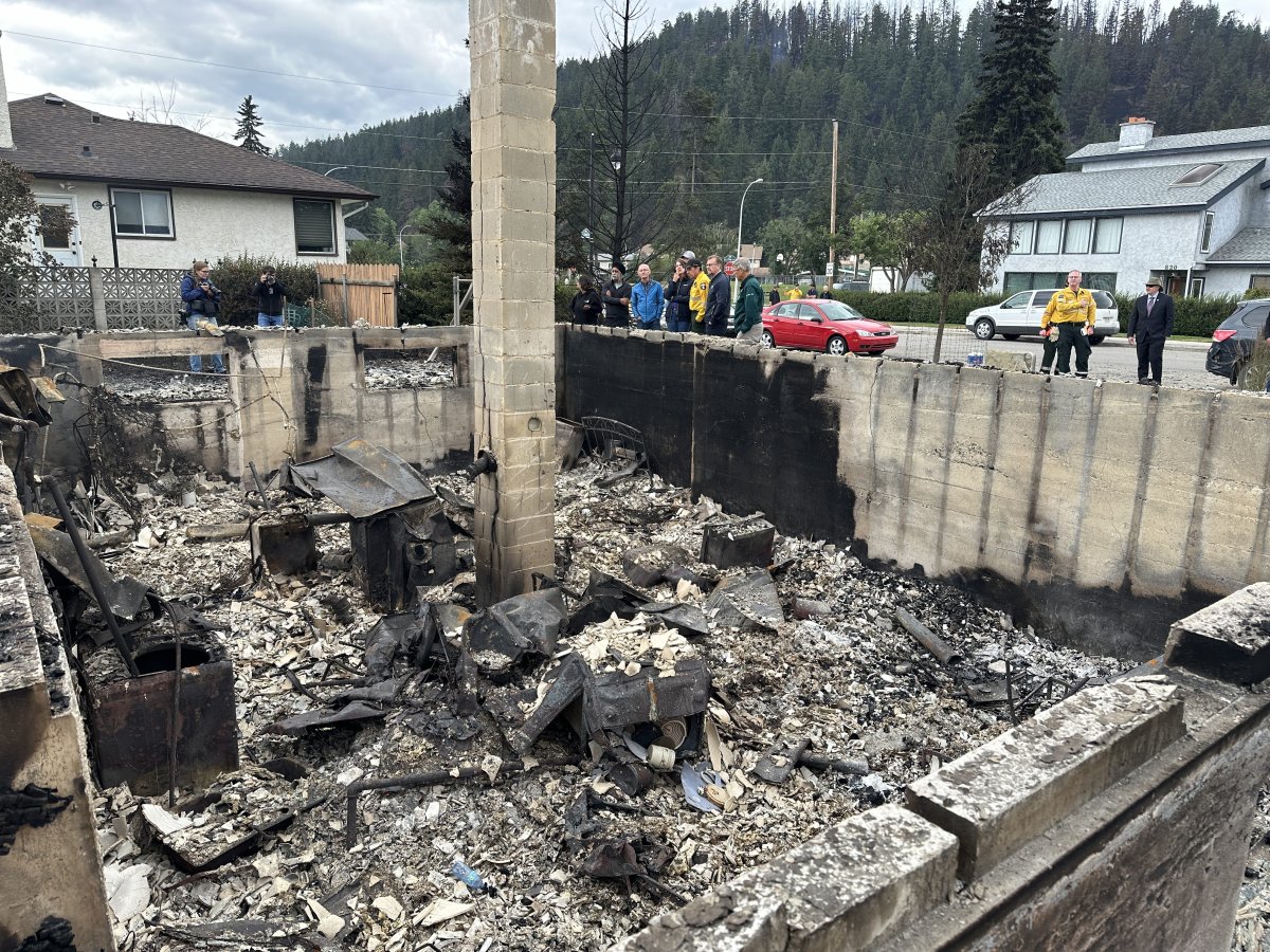 Alberta Premier Danielle Smith, Forestry Minister Todd Loewen and Federal Emergency Preparedness Minister Harjit Sajjan look on as Jasper Mayor Richard Ireland looks at the ruins of his family home of 67 years destroyed by wildfire.