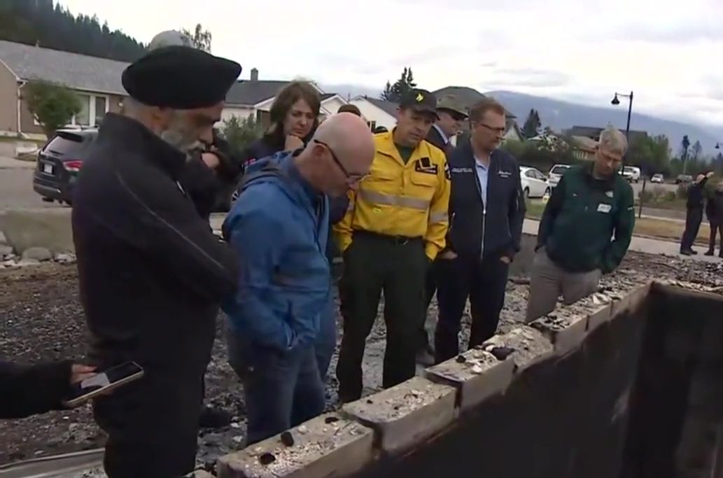 Alberta Premier Danielle Smith, Forestry Minister Todd Loewen and Federal Emergency Preparedness Minister Harjit Sajjan look on as Jasper Mayor Richard Ireland looks at the ruins of his family home of 67 years destroyed by wildfire. Friday, July 26, 2024.