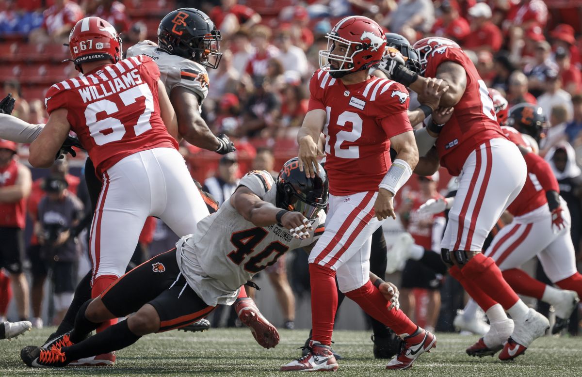 B.C. Lions Pete Robertson (40) grabs for Calgary Stampeders quarterback Jake Maier (12) during first half CFL football action in Calgary, Alta., Sunday, July 21, 2024.