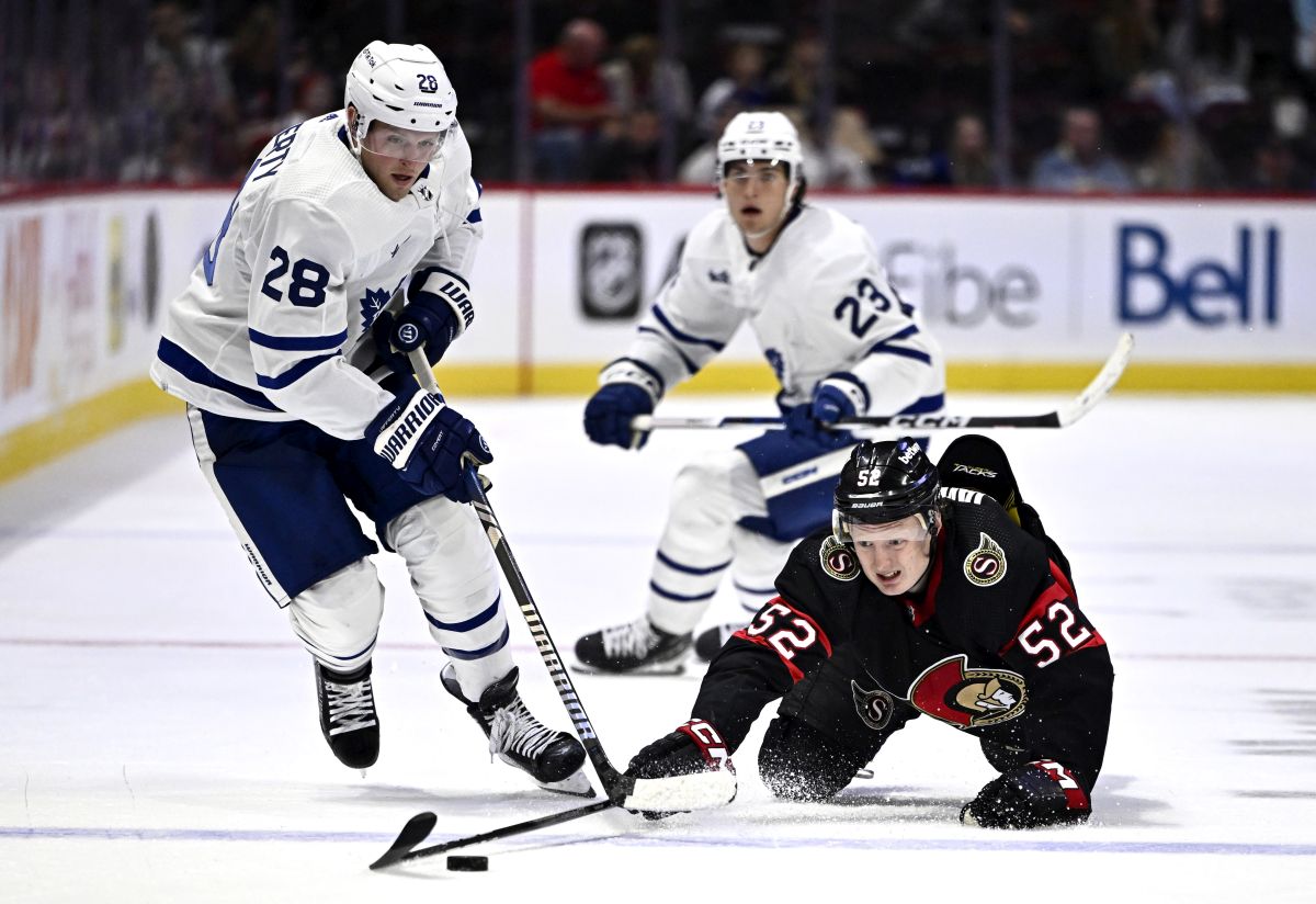 Ottawa Senators' Roby Jarventie (52) sprawls on the ice as he works to keep the puck away from Toronto Maple Leafs' Sam Lafferty (28) during second period NHL preseason hockey action in Ottawa, on Sunday, Sept. 24, 2023.