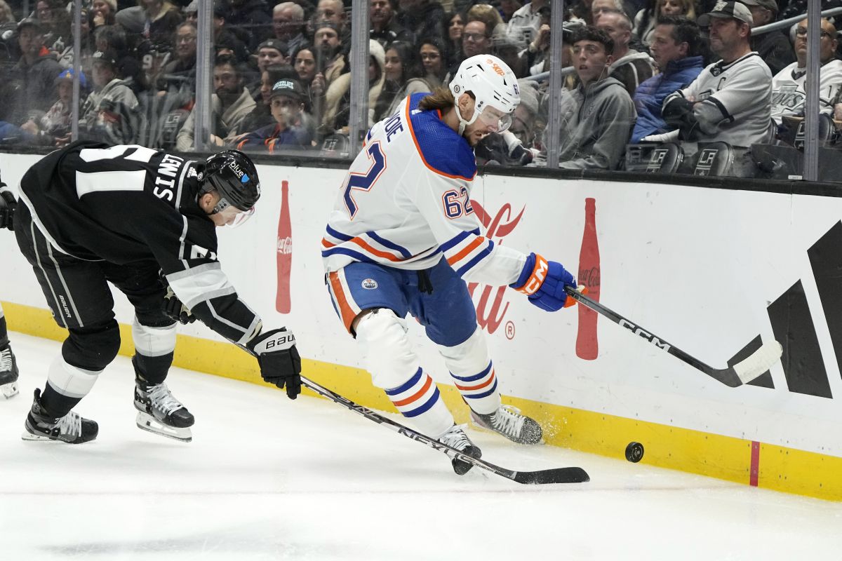 Edmonton Oilers centre Raphael Lavoie, right, takes the puck as Los Angeles Kings centre Trevor Lewis reaches for it during the first period of an NHL hockey game Saturday, Dec. 30, 2023, in Los Angeles.