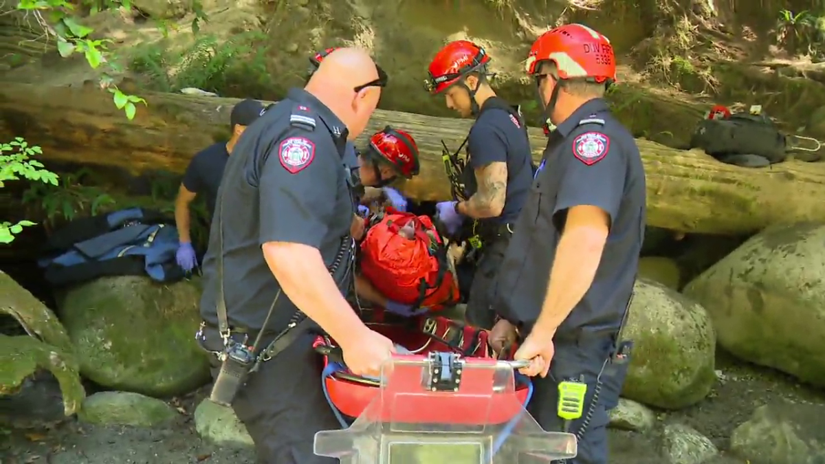 District of North Vancouver Fire and Rescue crews help a man who fell down a trail in Lynn Canyon on Sunday, July 7.